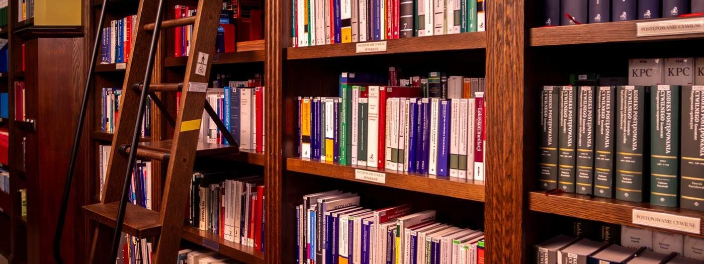 Estante de biblioteca com livros encadernados e escada de madeira